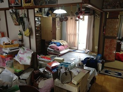 家の間取りは、和室が２部屋、洋室１部屋に台所の３DK。鍵をお預かりし、スタッフ３名９：００より作業開始。押入れには、たくさんの布団、扇風機・アイロンなどの家電品、贈答品、洋服（衣装ケース６箱）、 趣味の道具がぎっしりと つめ込められていました。 布団・衣類・家電品・ガラス製品陶器・道具類・贈答品・プラスチック類に仕分けをして運び出し作業。 もう一部屋の和室には、 すべての引き出しが洋服でいっぱいの大きな洋服タンスが２台。 趣味の作品や調度品飾ってある飾り棚が１台ありました。こちらも、衣類・飾り棚のガラス扉・タンスに付属している鏡(取外し)・ 木製のテーブル・紙類(本・新聞紙）に仕分けをして運び出し作業。台所にかけては、冷蔵庫、電子レンジ 食器棚、ダイニングテーブル、食品類が中心にありました。家電品・陶器・ガラス・木製品に仕分けを行います。缶詰や飲料類は、すべて中身をだして缶・瓶・ペットボトルに仕分けます。 洋室には、健康器具、空気清浄器といった家電品のほか、洋服タンス(中)が１台、３段ボックスなどありました。 こちらの仕分け作業中には、アルバム、パスポート、現金などの貴重品がタンスの引き出しから見つけ出すことができました。 当社では、作業中に見つかった貴重品や探し物が見つかったものは、思い出BOXへ厳重に保管しています。 また、作業中に必要なのか不要なのか判断に迷ったものは、随時電話にてご連絡をしています。 ベランダには、趣味の道具や作品が詰められた段ボールが20箱のほか、未使用ままの掃除機、壊れたストーブなどが積み重ねられている状態でした。 ２年間、雨風に打たれた段ボールの一部はボロボロに劣化していました。 すべてものを運び出した後、しっかり清掃作業を行いました。 １６：００作業完了。 作業時間６時間　スタッフ３名　